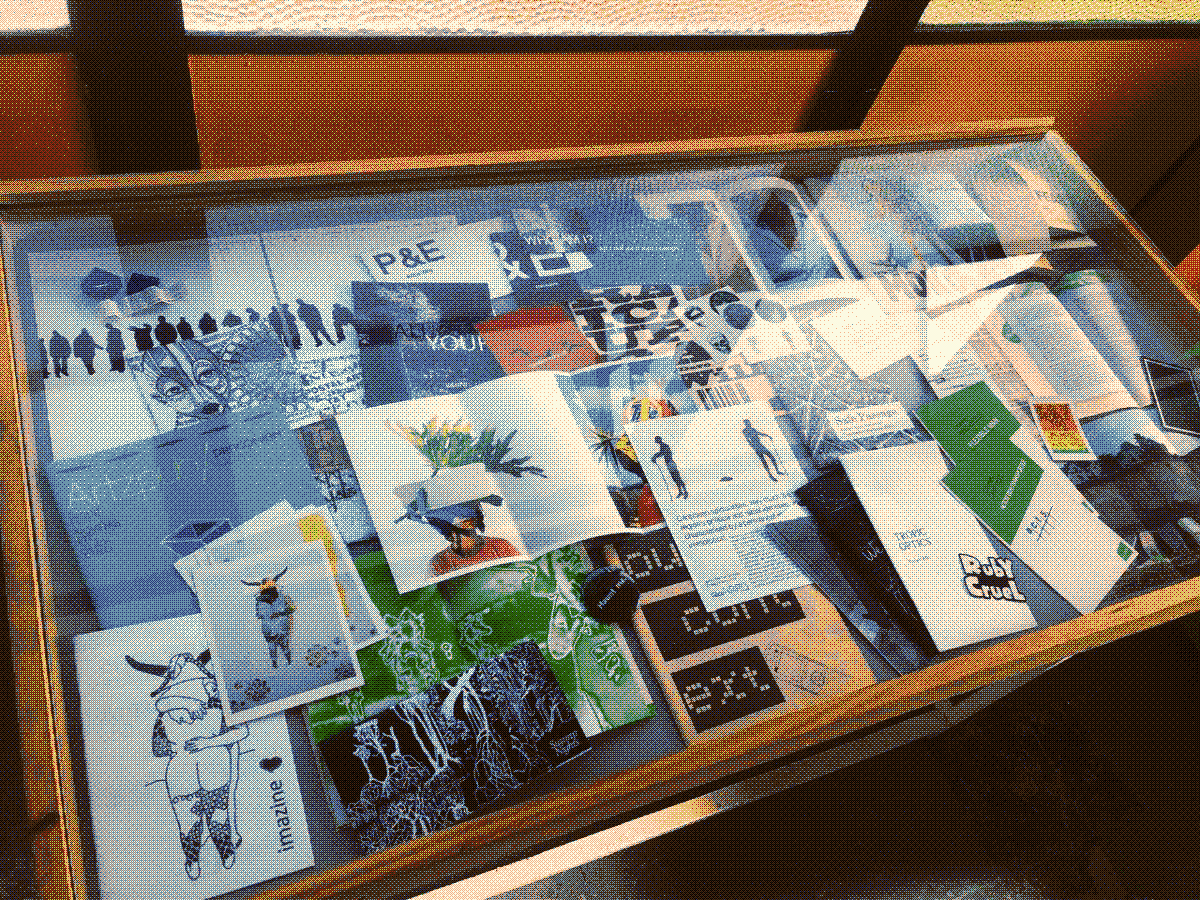 Picture of a clear table showcasing various older local zines.